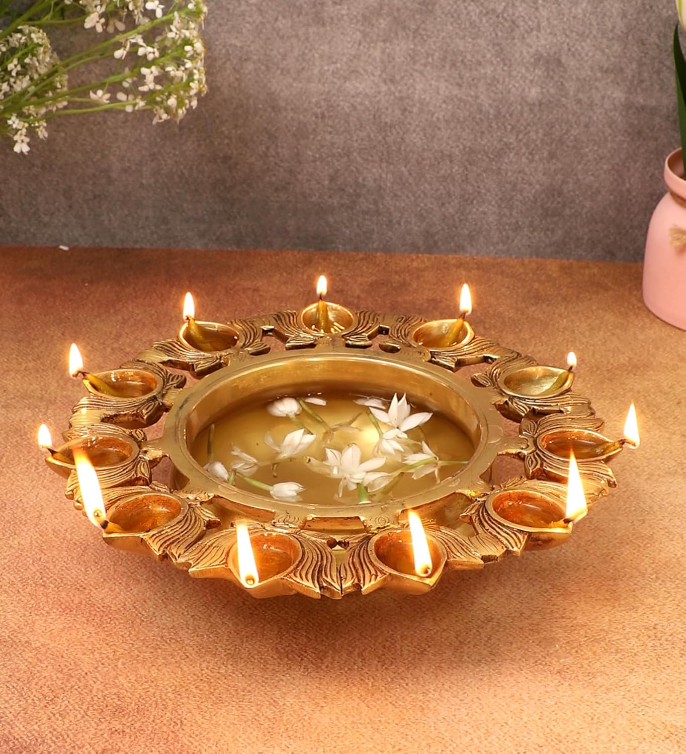 Brass Urli Bowl dengan reka bentuk Lotus 11 Diyas / Brass Urli Bowl with Lotus Design 11 Diyas Antique Yellow Dimensions: Length: 9.5 inches (23.7 cm) Width: 9.5 inches (23.7 cm) Height: 2.5 inches (6.2 cm) Diameter of Bowl : 6 Inches (15 cm)